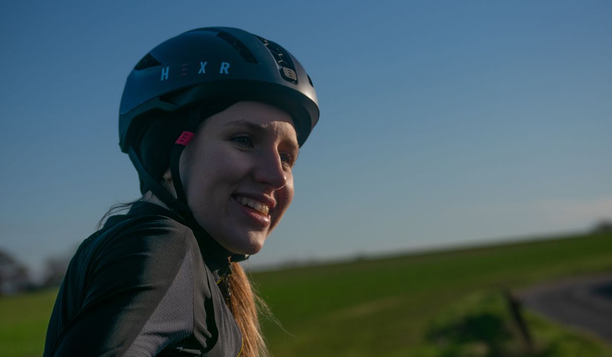 Keira McVitty cycling wearing a bicycle helmet
